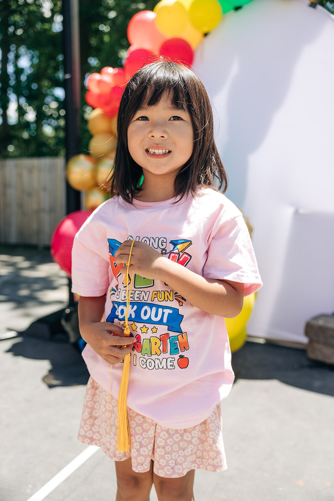Girl wearing a Sylvania Children's Center shirt and smiling outdoors