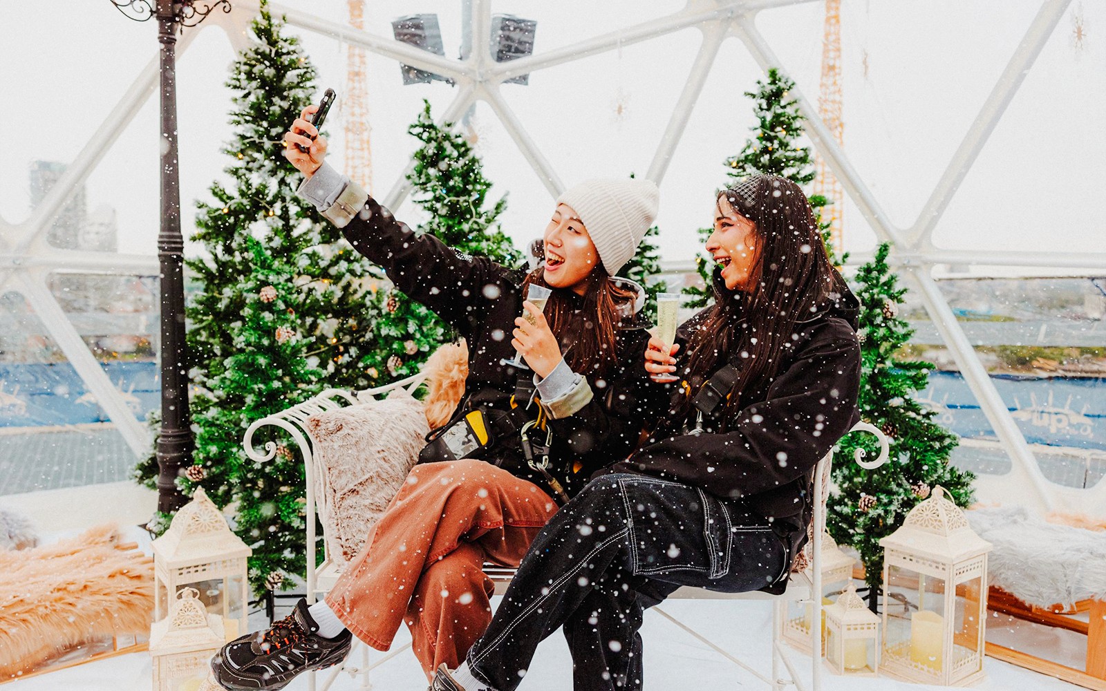 客人在 O2 雪球体验活动中尽享雪景与节日装饰的乐趣。