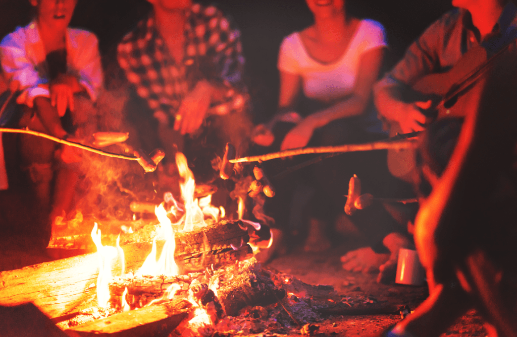 group sitting around campfire roasting marshmallows