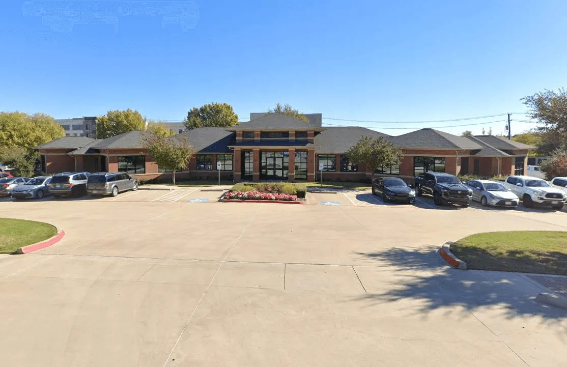 Single-story office building with parking lot in front.