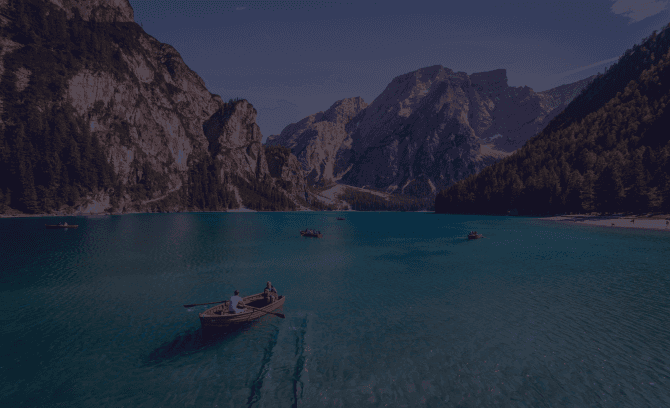 Lake with view of mountains and people on boats