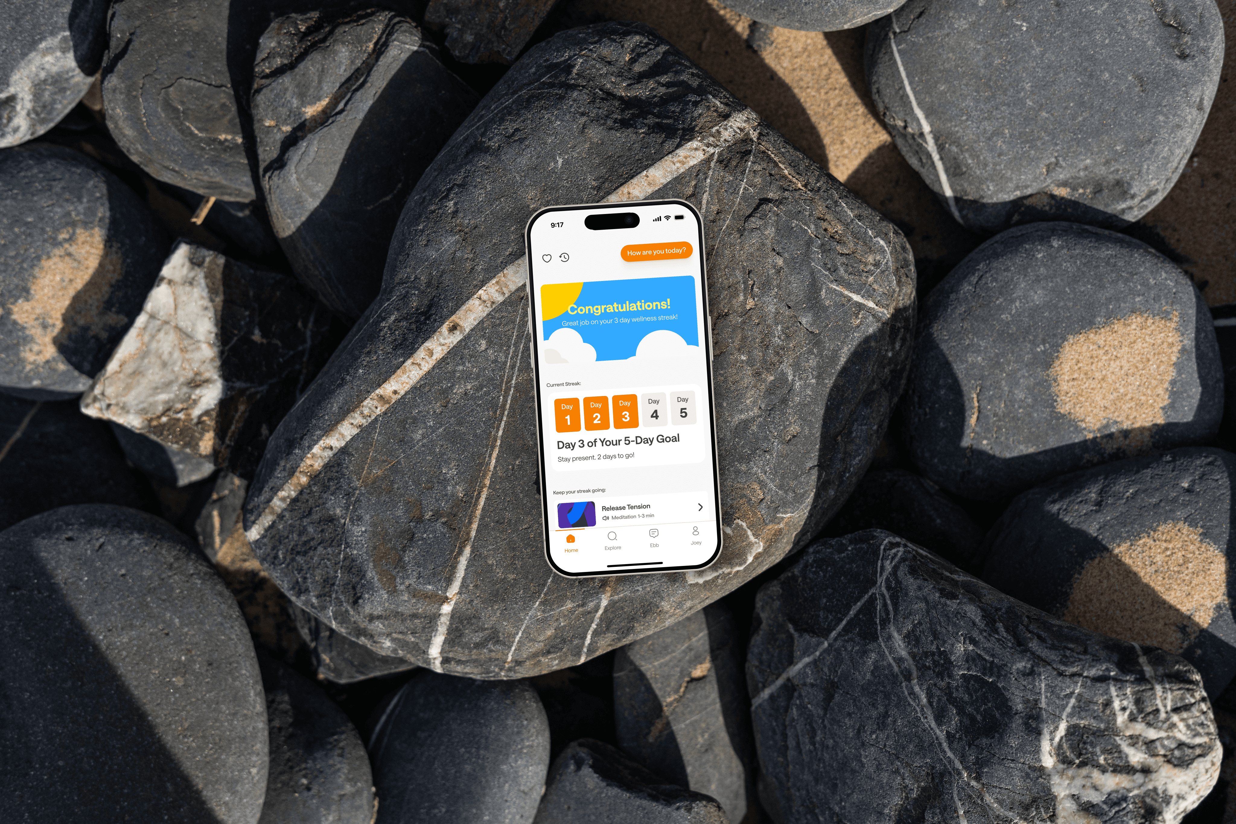 Phone on rocks, displaying the redesigned home screen for Headspace.