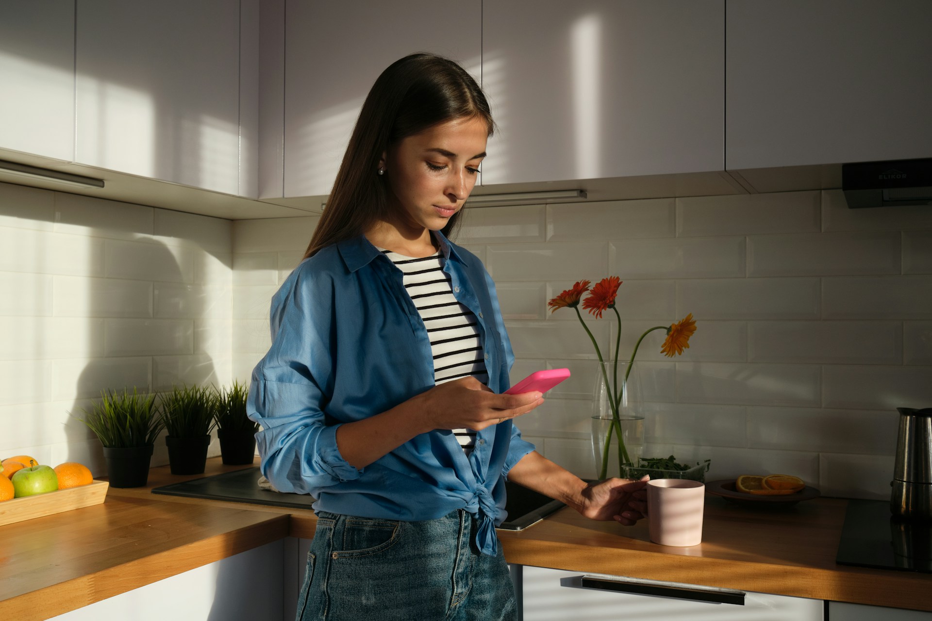 Lady on her phone in a kitchen