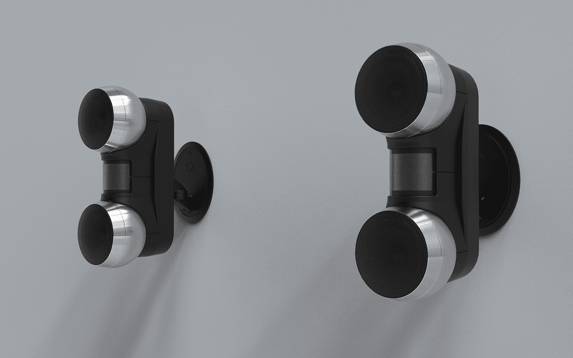 Two black wall speakers with silver accents