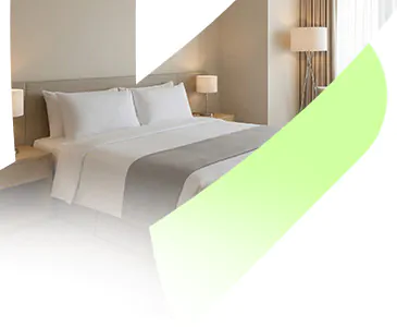 Quarto de hotel confortável com cama de casal bem arrumada e iluminação acolhedora, representando as hospedagens selecionadas pela Livare Viagens no Circuito Andino.