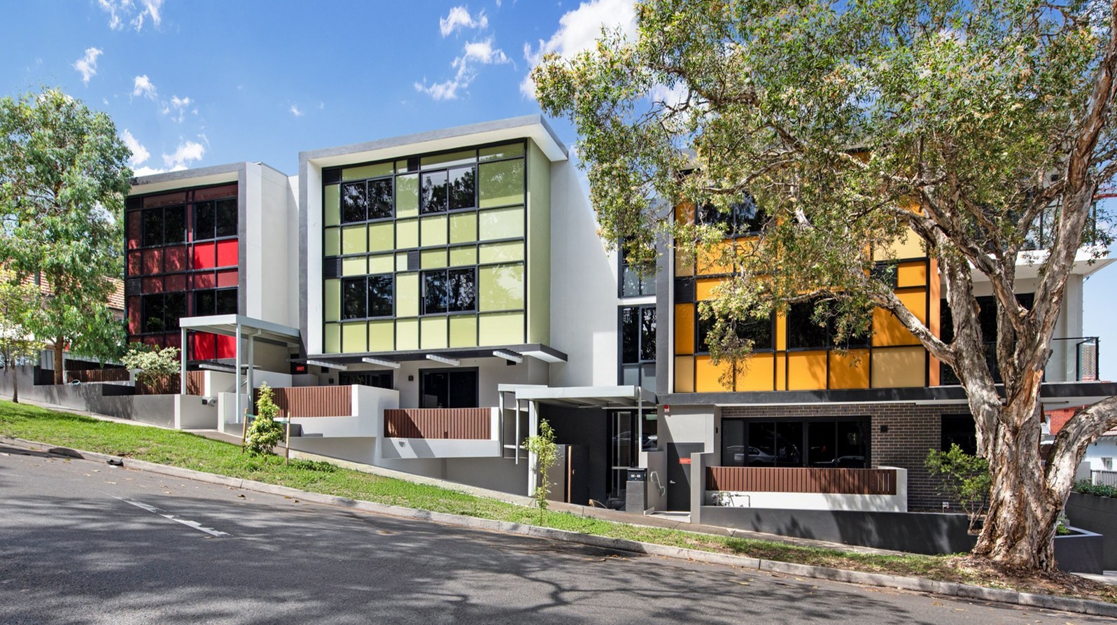 A cozy apartment layout with a bedroom featuring a double bed and two nightstands. A living room has a sofa, armchair, TV, and red rug. A kitchen and dining area with a round table and plants enhance the space's modern, inviting feel.