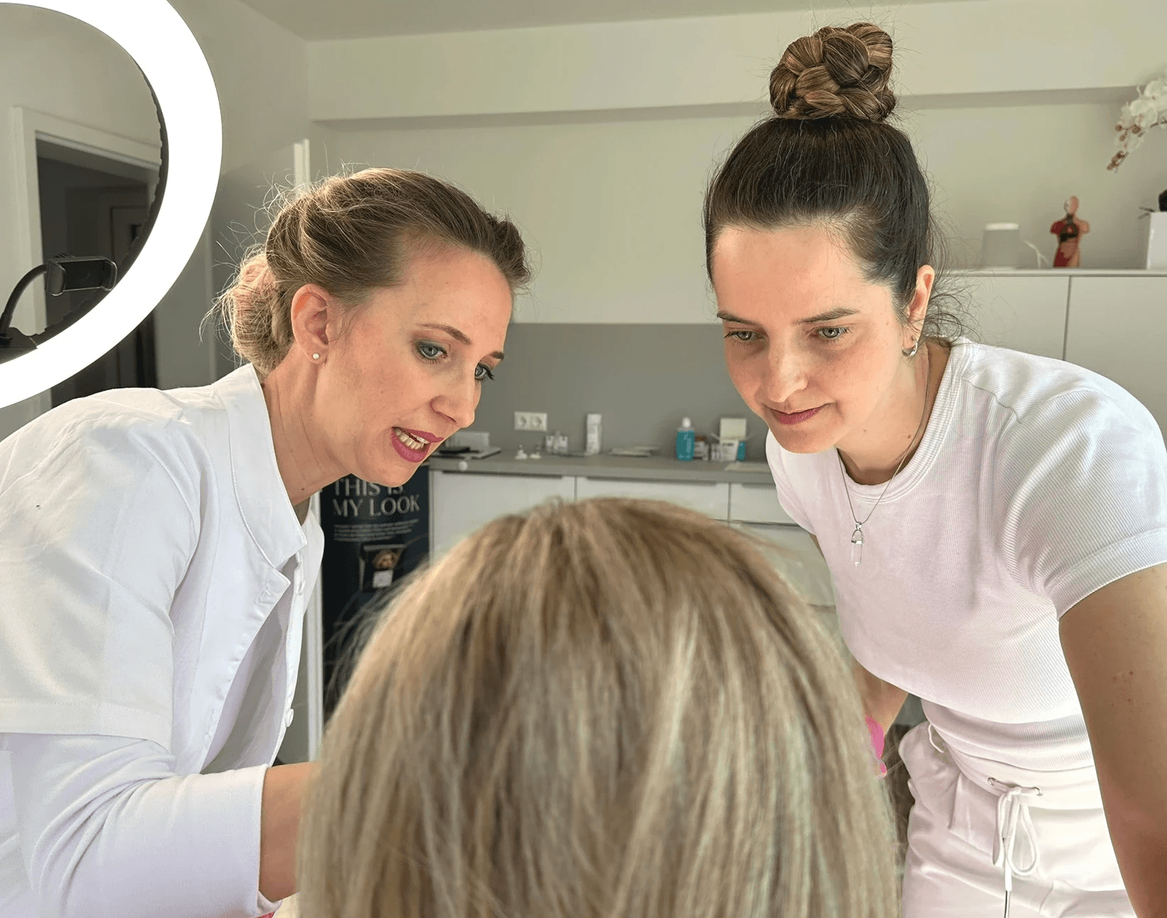 Praktische Schulung: Teilnehmerin führt eine ästhetische Behandlung unter Anleitung der Dozentin Kerstin Liebl durch.