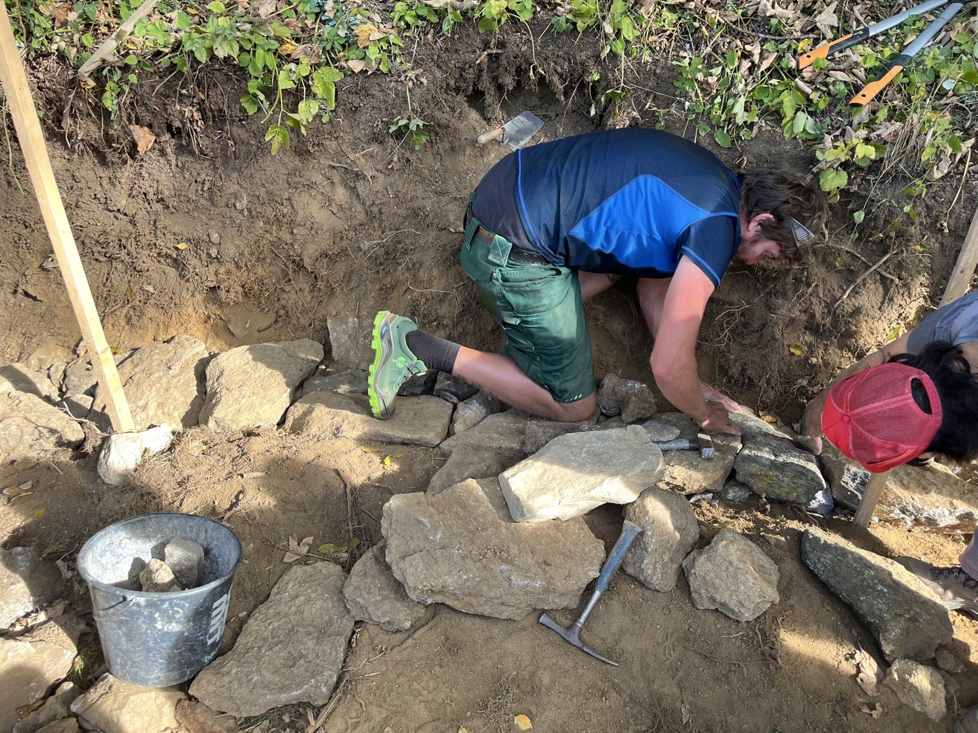 Teilnehmer setzt Tockenmauer Fundament