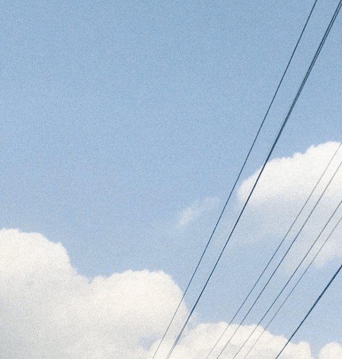 A close-up of a person wearing green-tinted glasses, with a serious expression and smooth skin.