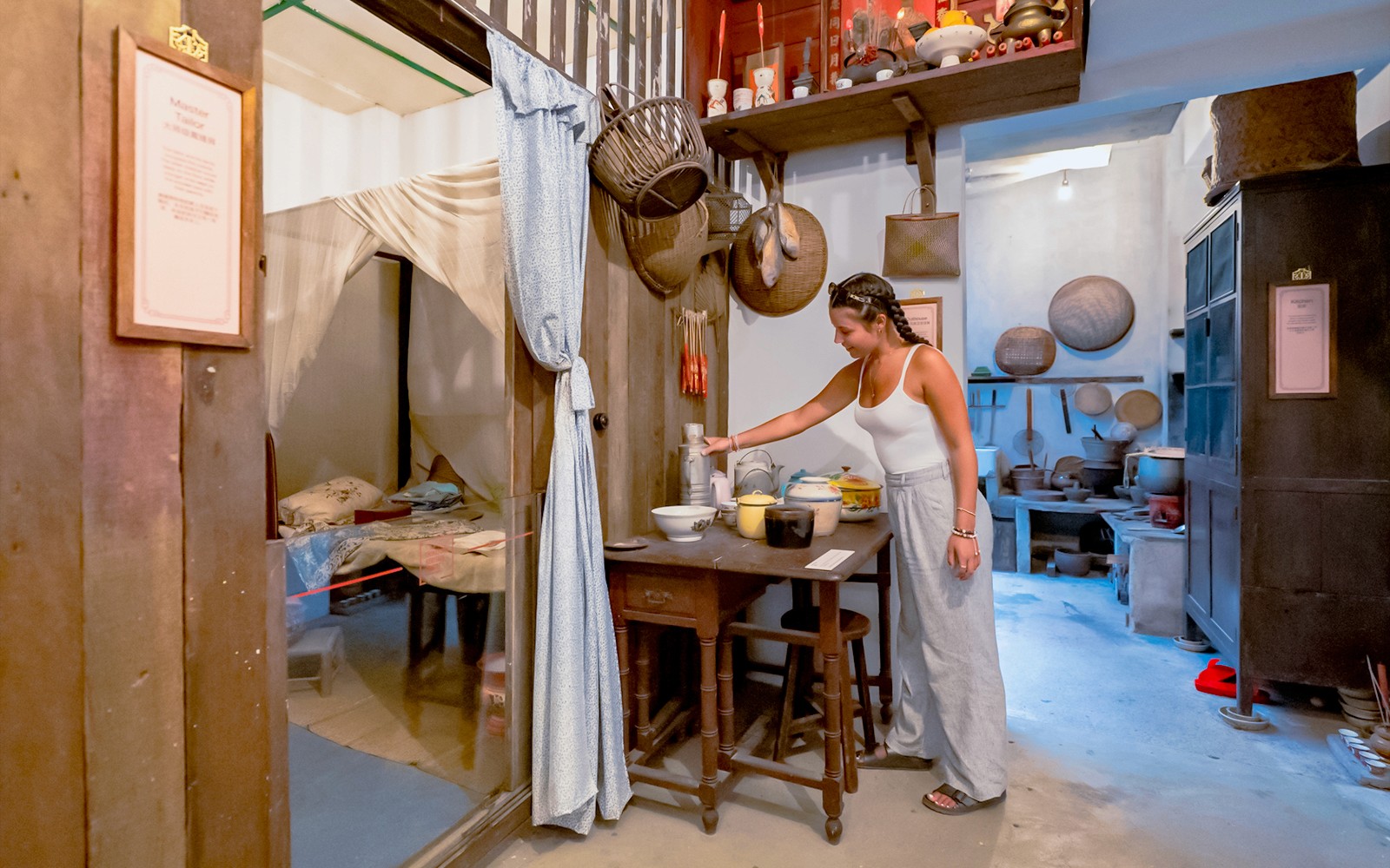 Visitor exploring exhibits at Chinatown Heritage Centre, Singapore, showcasing cultural artifacts and historical displays.