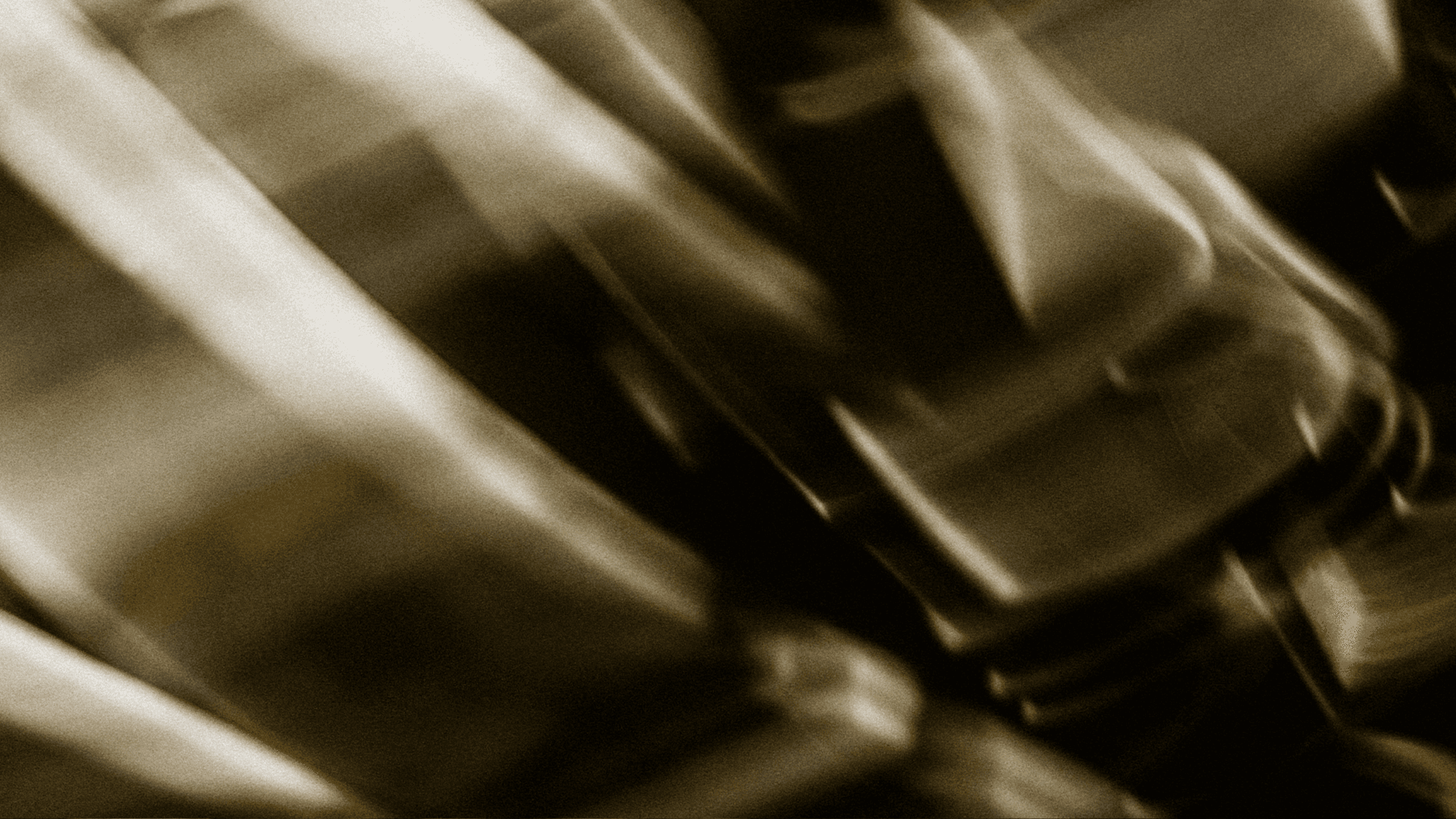 Abstract blurred metallic texture with diagonal light streaks in sepia tones