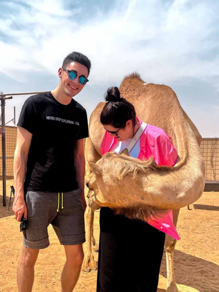 chris and loz with a camel in the desert, dubai