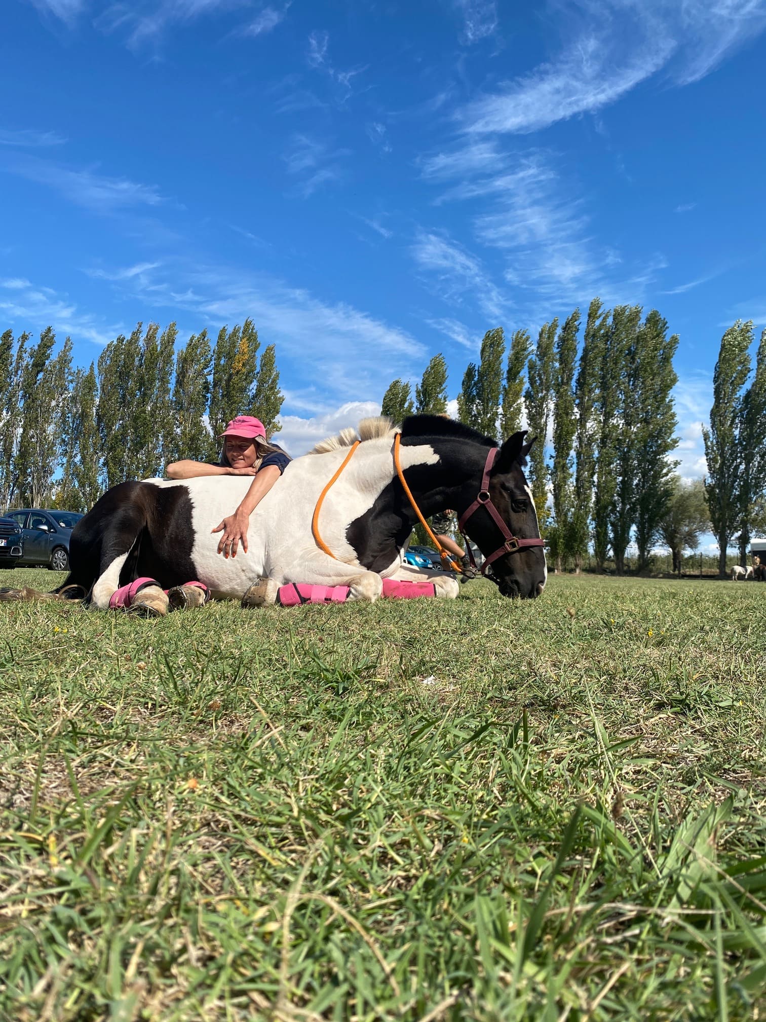 Lucie Boils, fondatrice du Ranch Pegase, en pleine complicité avec son cheval pie dans l'herbe à Bessan.