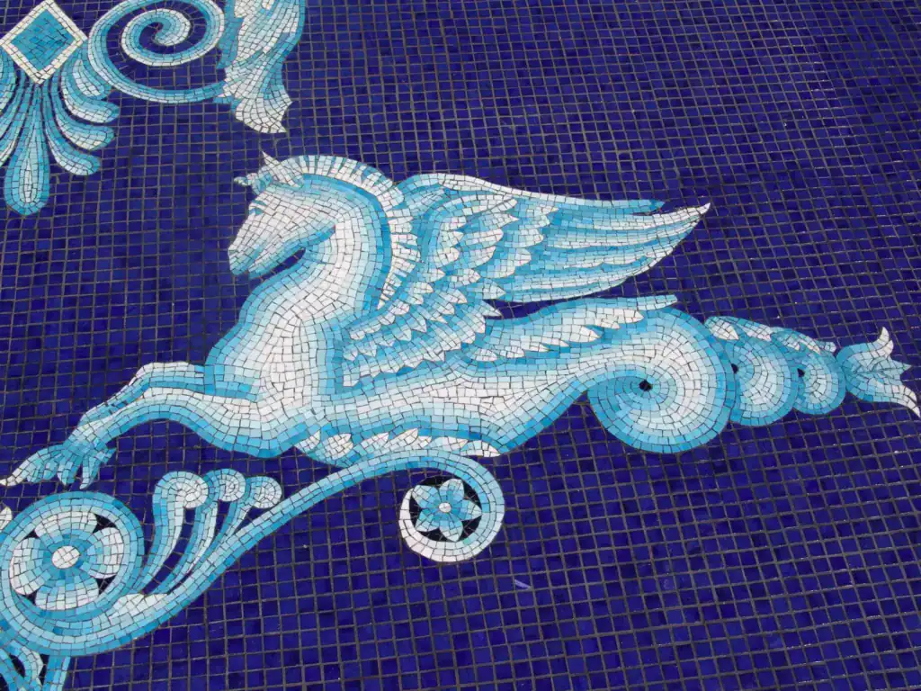 Hippocampus mosaic being set into the floor of an all-tile pool during installation — Mosaiclegs Art Studio