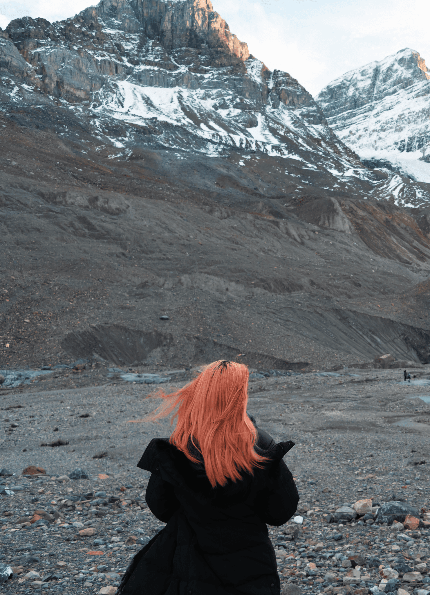 A person holding a camera is silhouetted against vivid orange stage lights. The scene conveys focus and creativity with a dramatic, moody atmosphere.