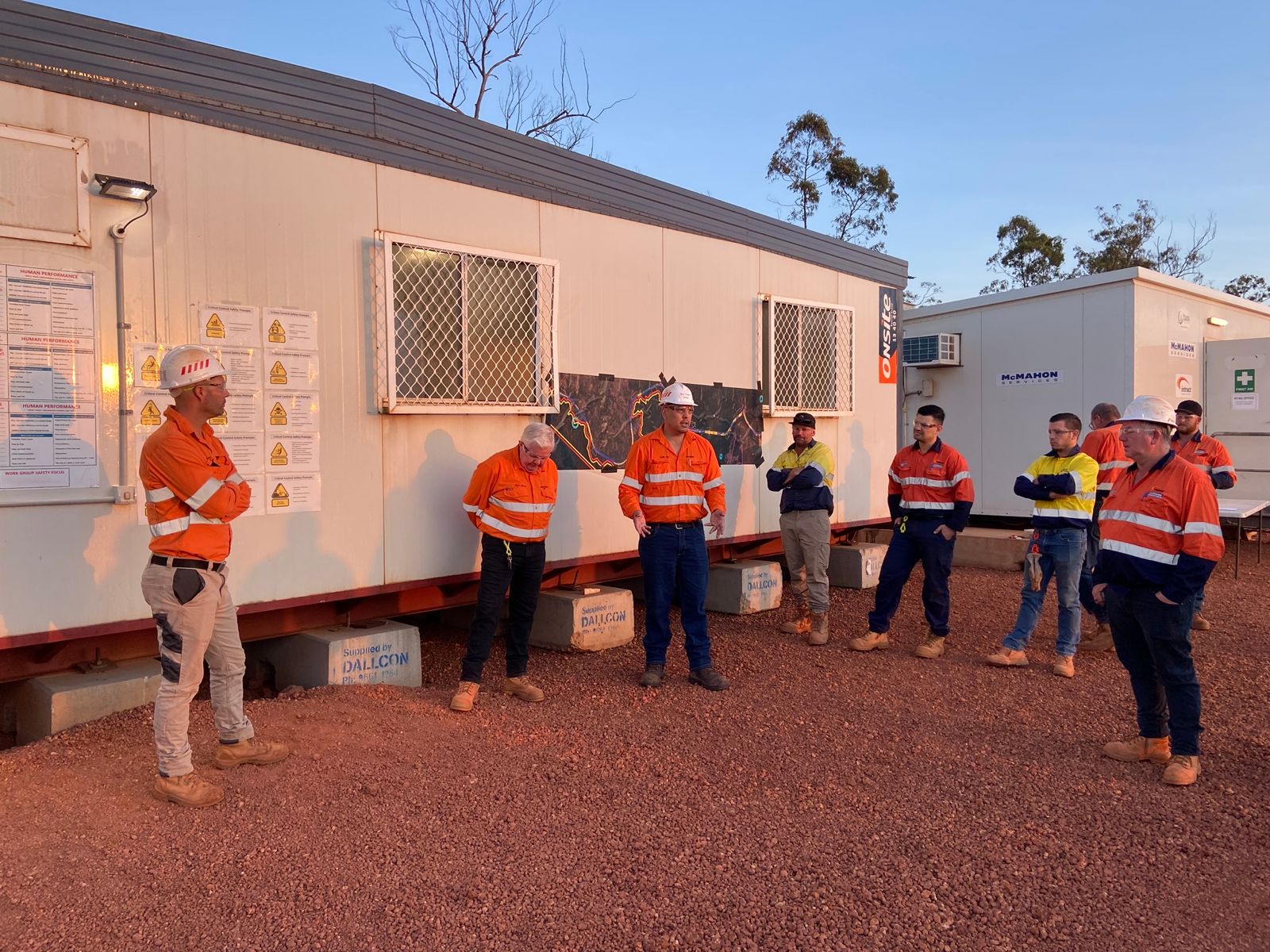 UMINEX project team in hi-vis running a site briefing outside a temporary site office