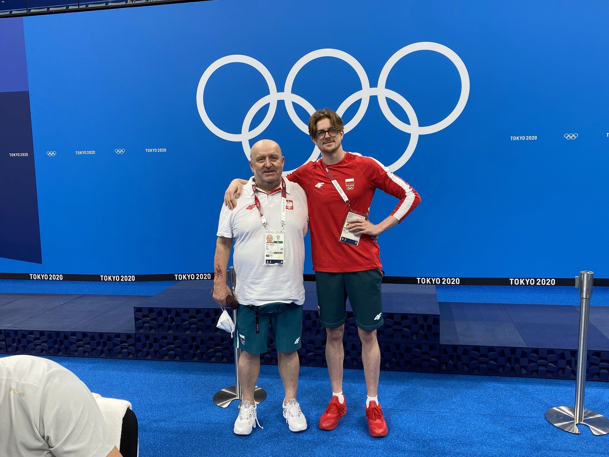 A man stading with Surfboard