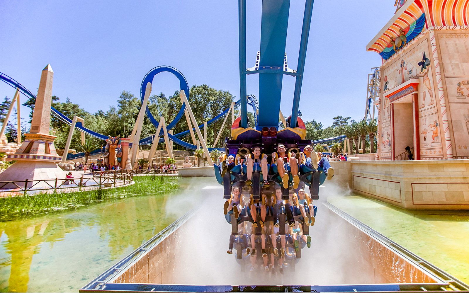 Tourists on a roller coaster at Astérix Park near Paris, with Egyptian-themed decor.