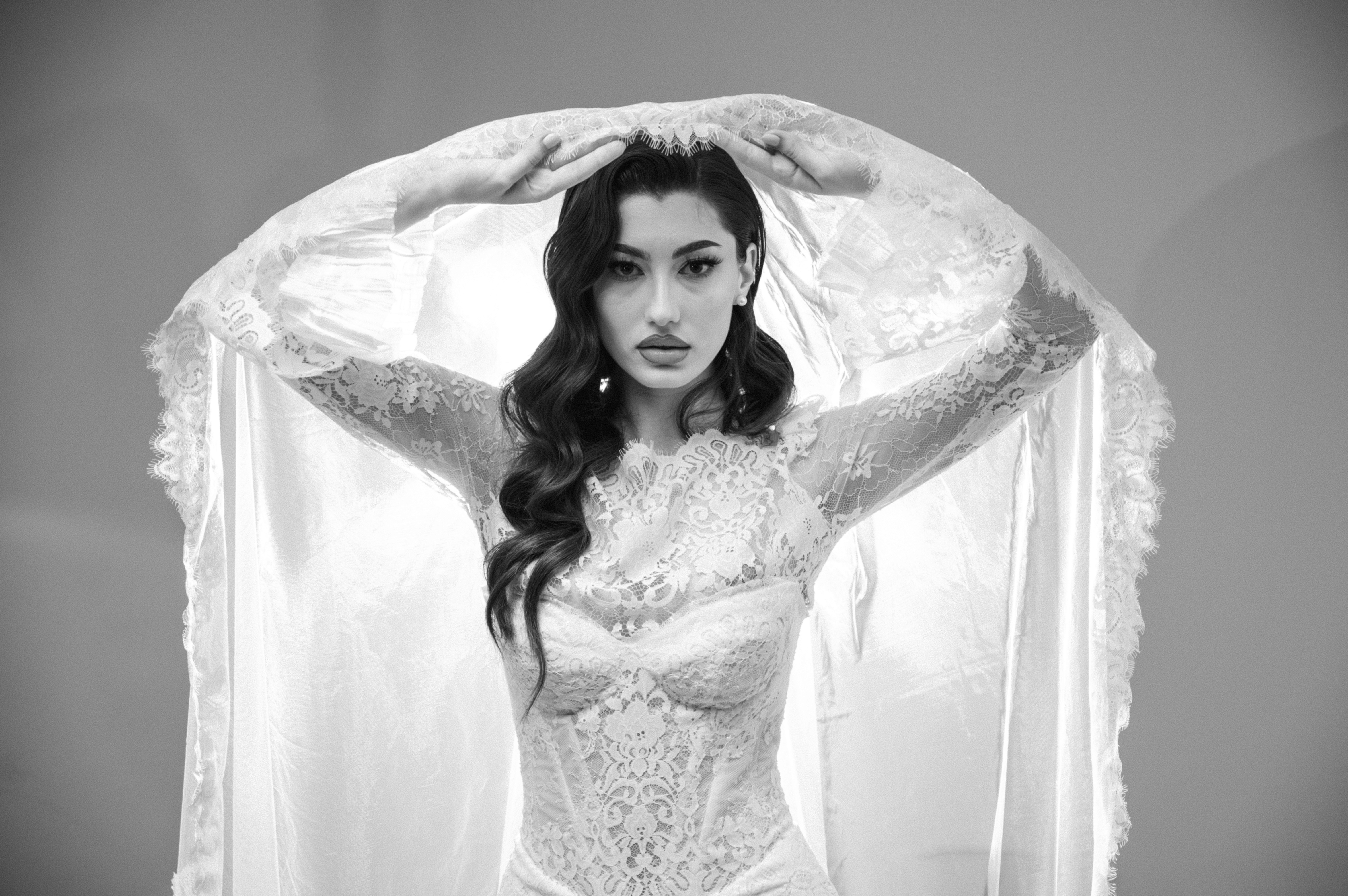 Portret alb-negru de mireasă cu voal ridicat și lumină dramatică, fotografie bridal în București