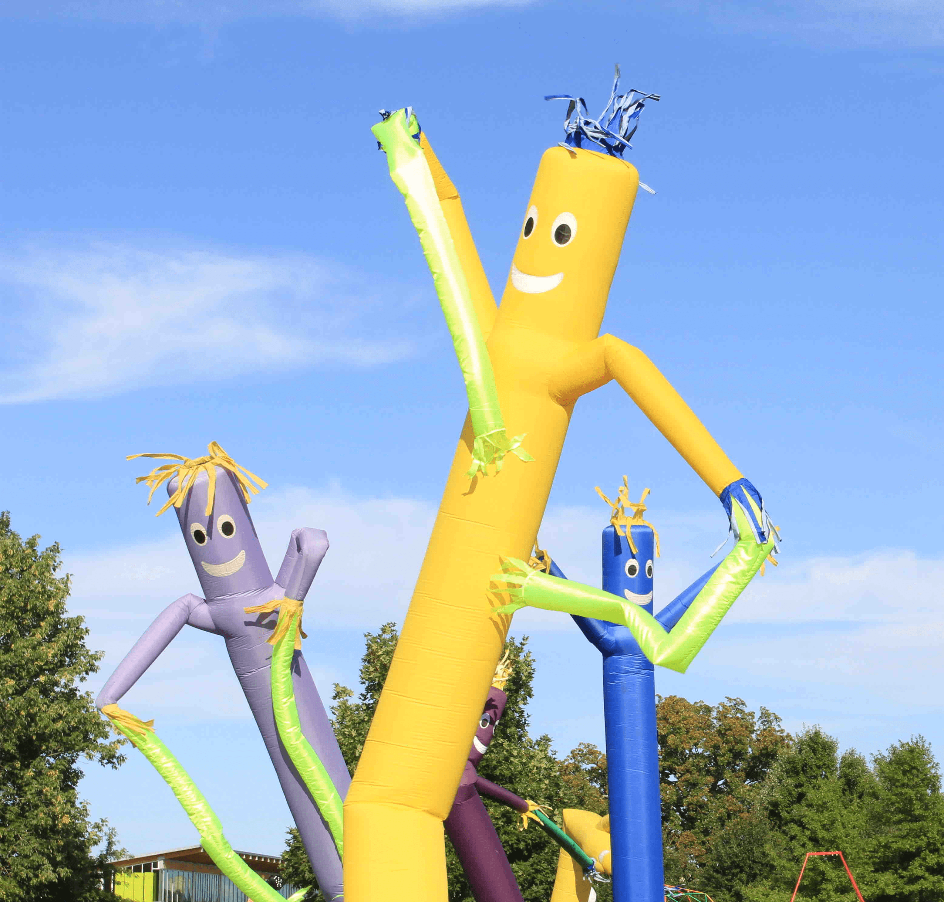 Colorful abstract sculptures in vibrant yellow, blue, and green against a clear blue sky.