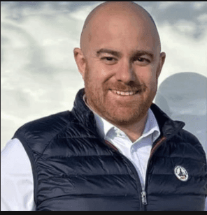 a man with a goatee smiles at the camera