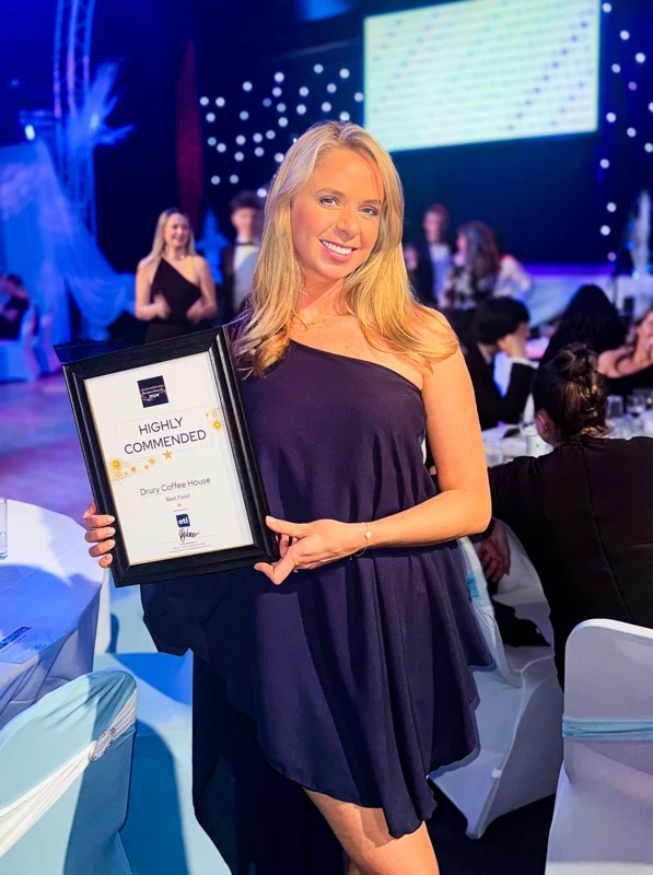 owner smiling with commendation award