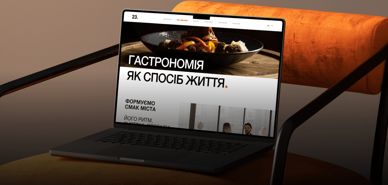 Laptop on an orange chair showing the restaurant group homepage