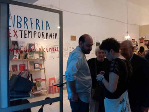 A group of people talking in a library hall.