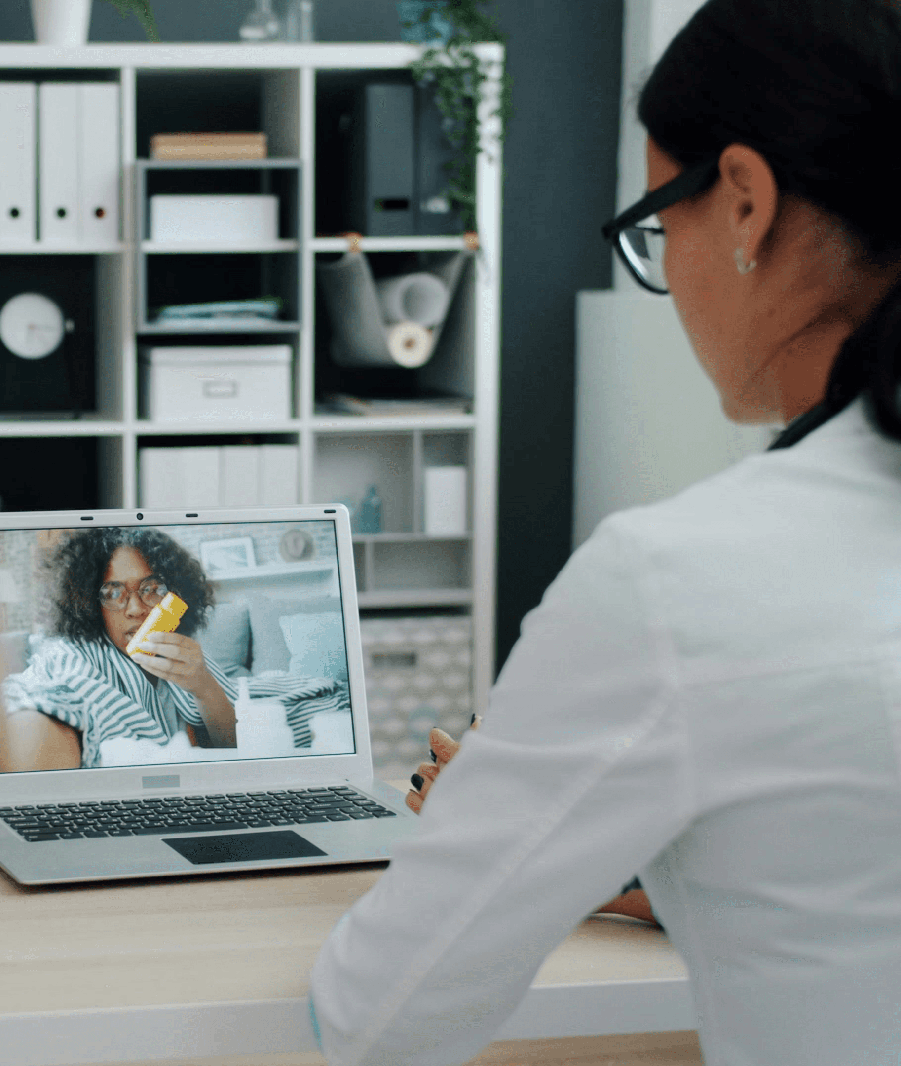 Doctor consulting patient via video call on laptop.