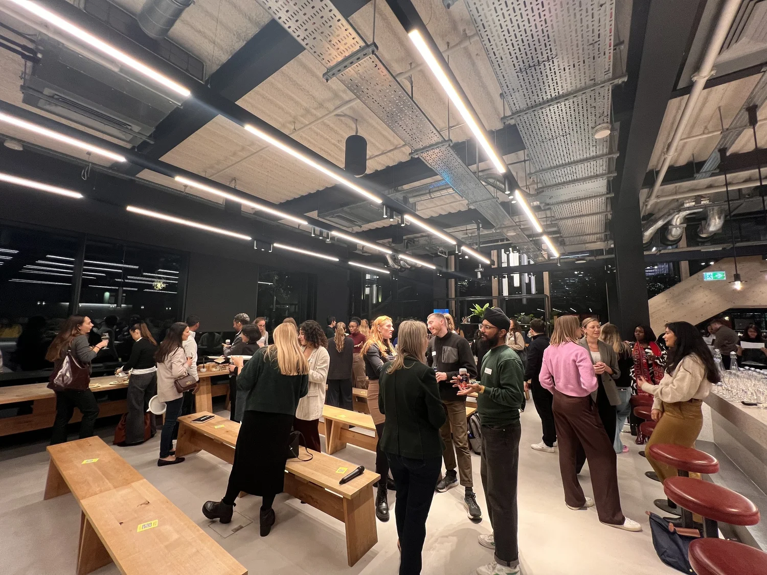 Group of people chatting around wooden benches