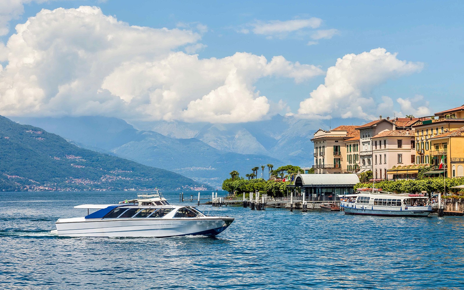 Croisière en bateau sur le lac de Côme avec des montagnes et des bâtiments colorés en arrière-plan.