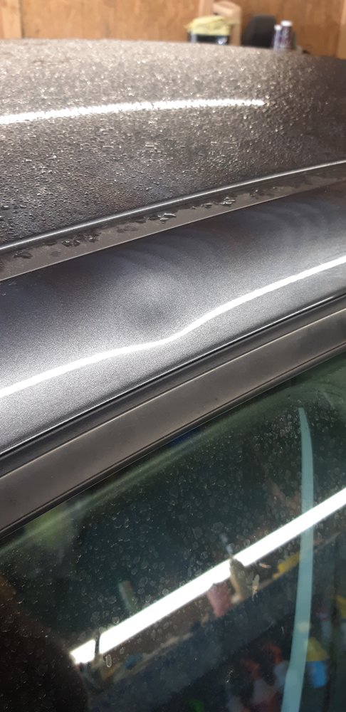 Kia Forte roof rail dent from an angry fist