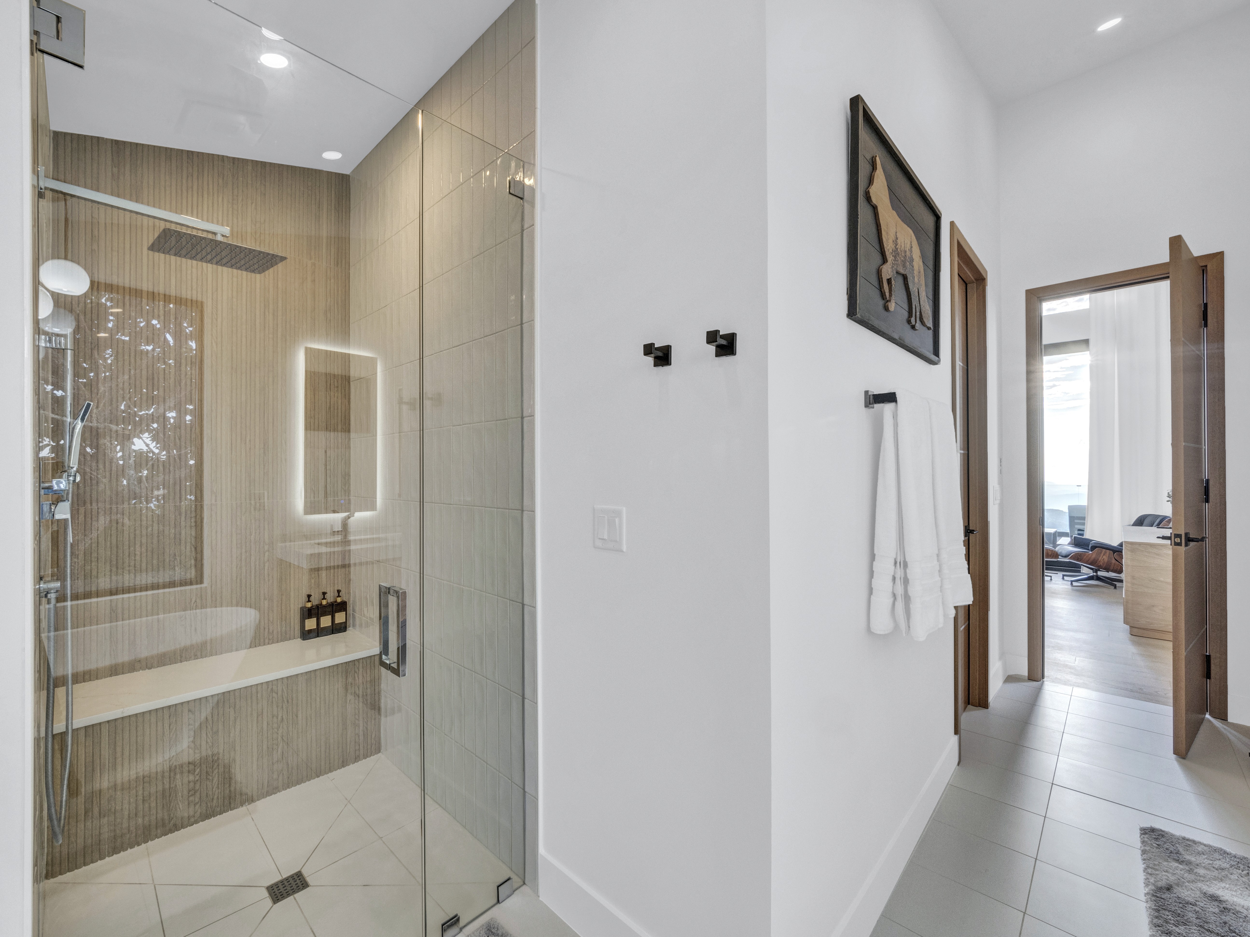View from the master bathroom looking toward the bedroom, featuring modern artwork and clean architectural lines