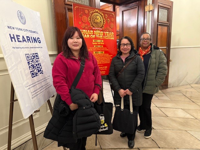 Grand Street staff in front of a sign for the New York City Council Lunar New Year party.