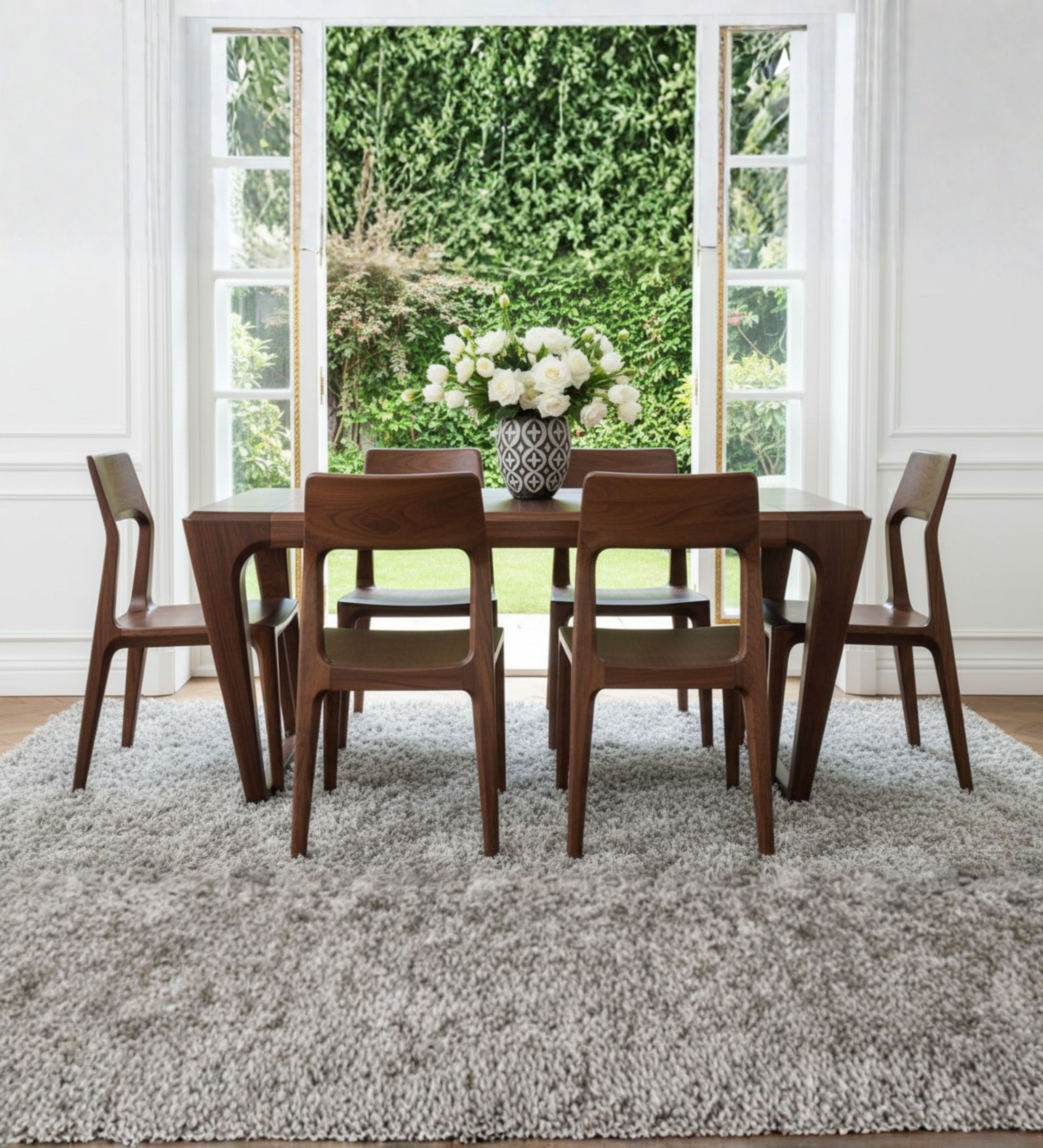 Modern classic wooden dining table with squared proportions and gently curved wooden chairs