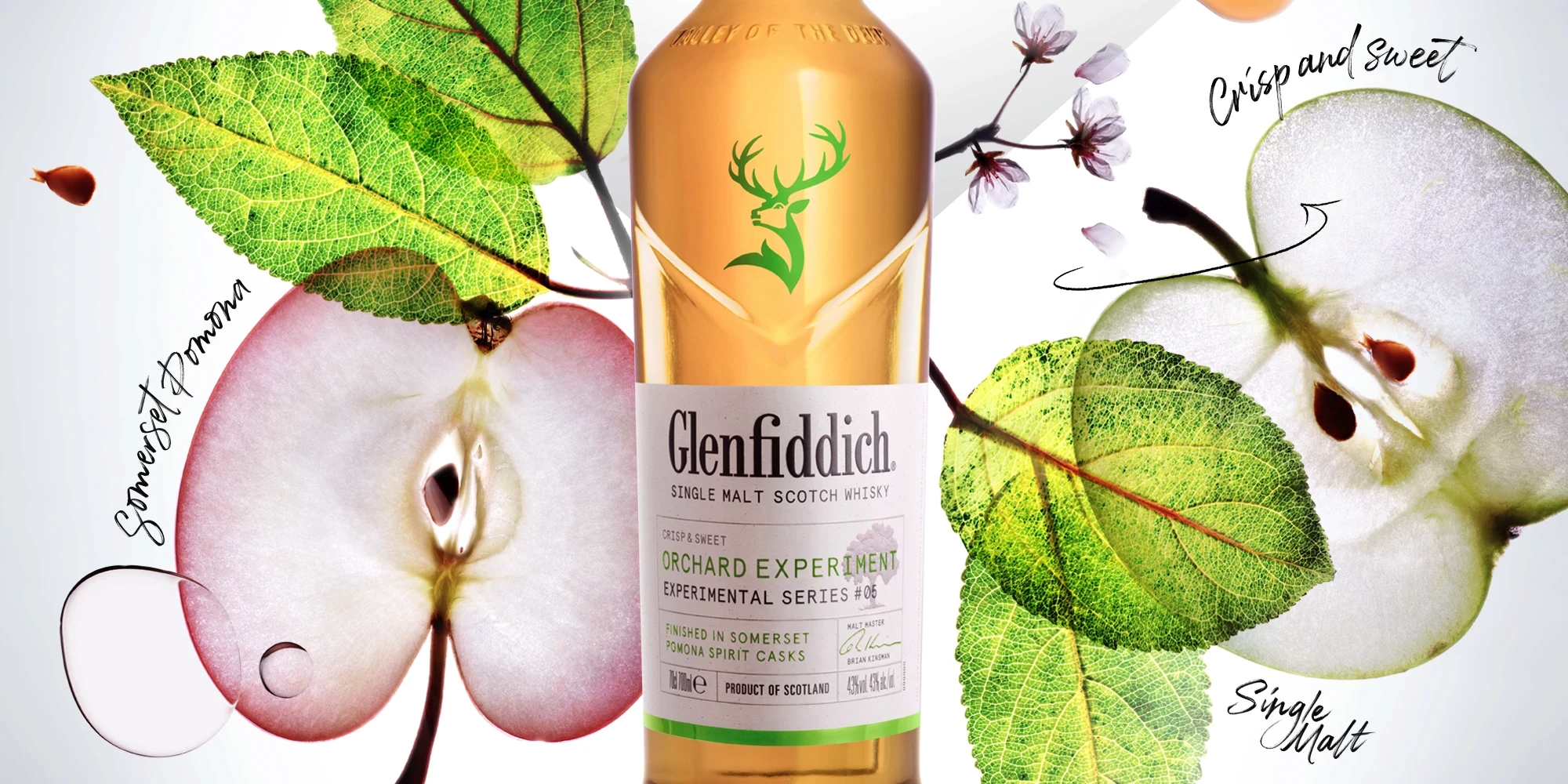 Glenfiddich whisky bottle in front of sliced apples, leaves and blossom twigs