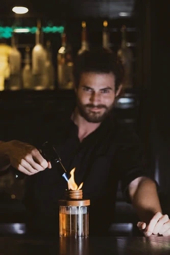 Bartender working behind a bar with ambient lighting
