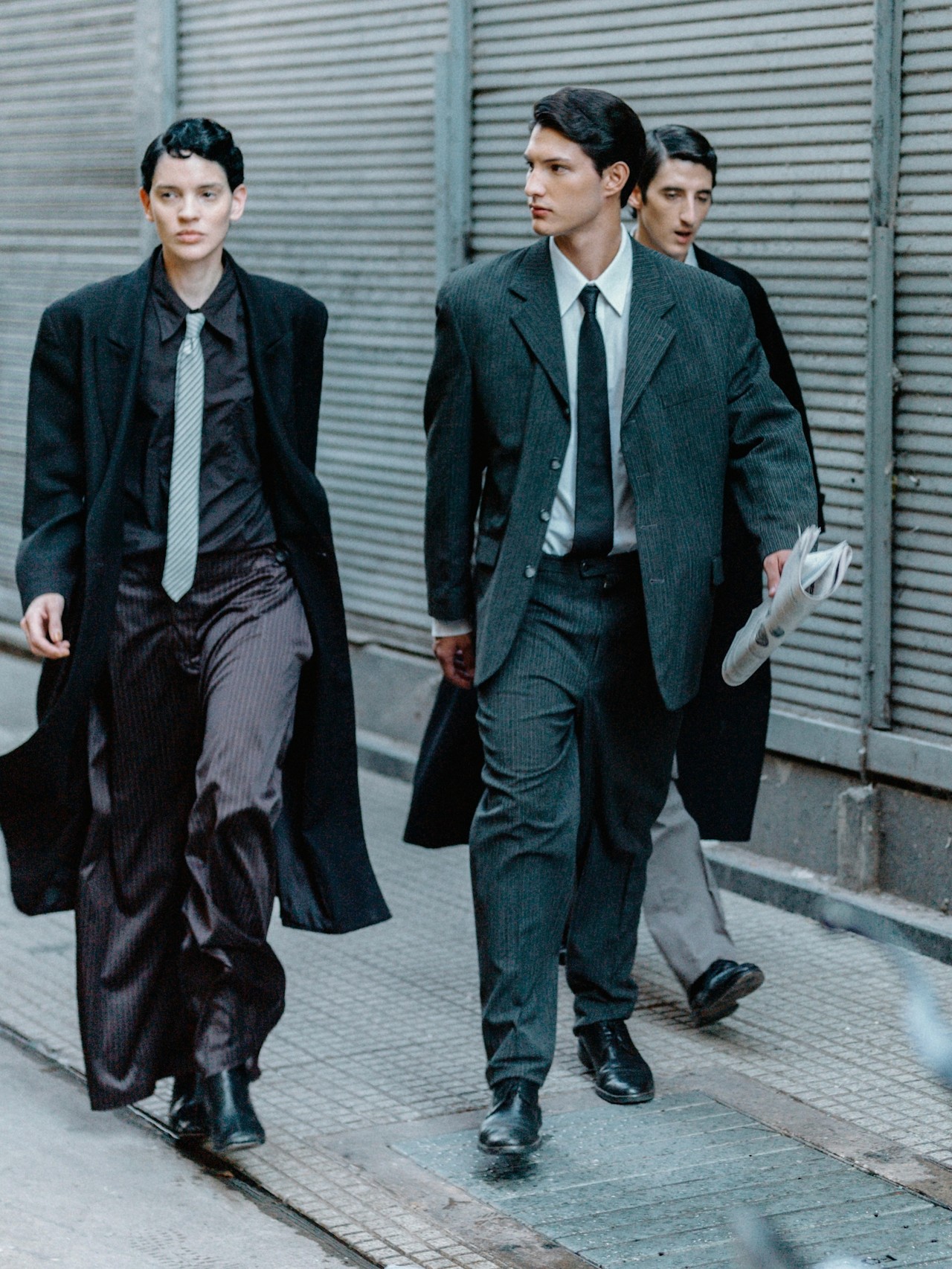 A minimalist still life of a milk bottle and a black high-heeled shoe on a pink background.
