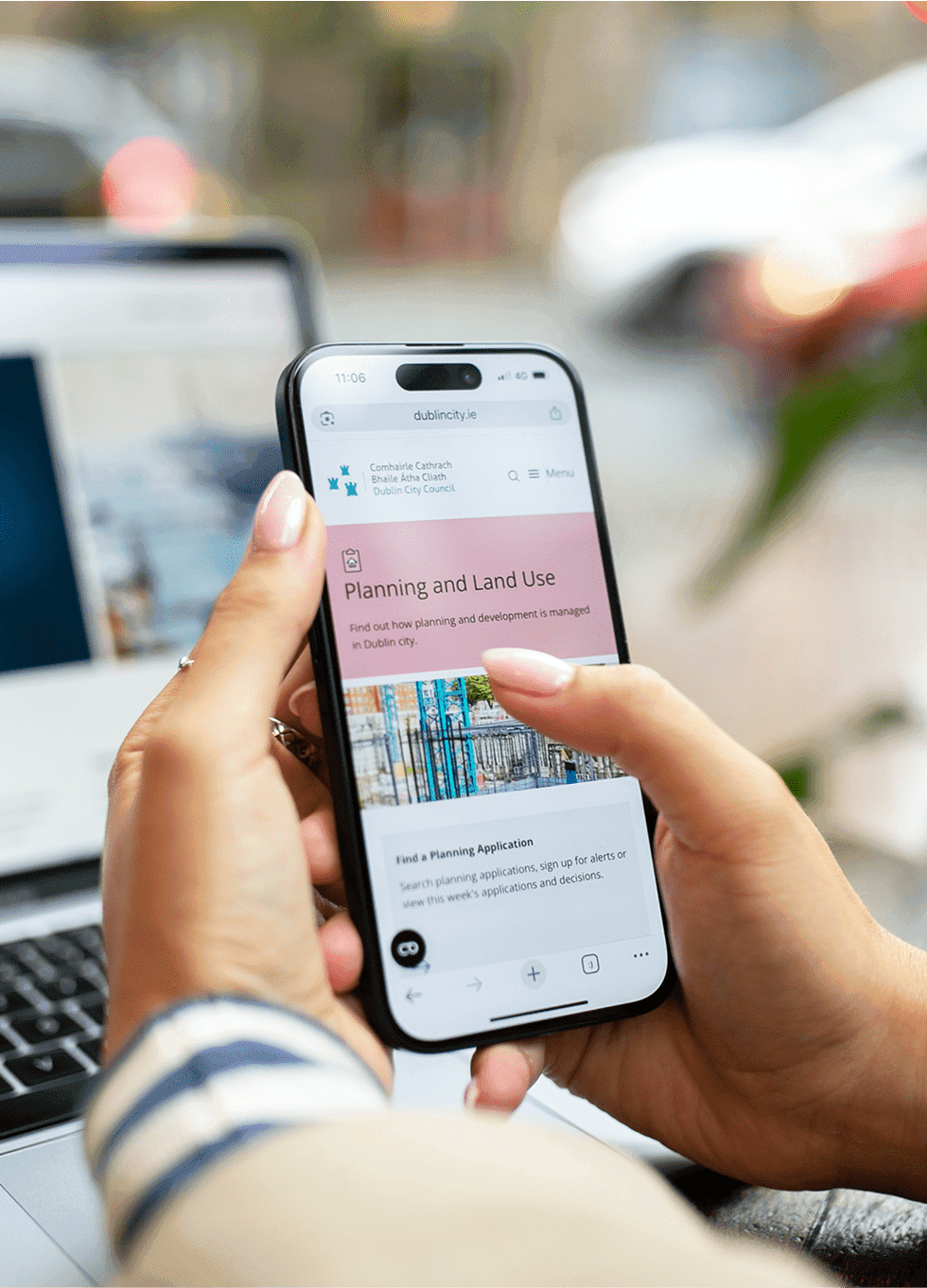 Person holding a smartphone displaying the new Dublin City Council website interface.