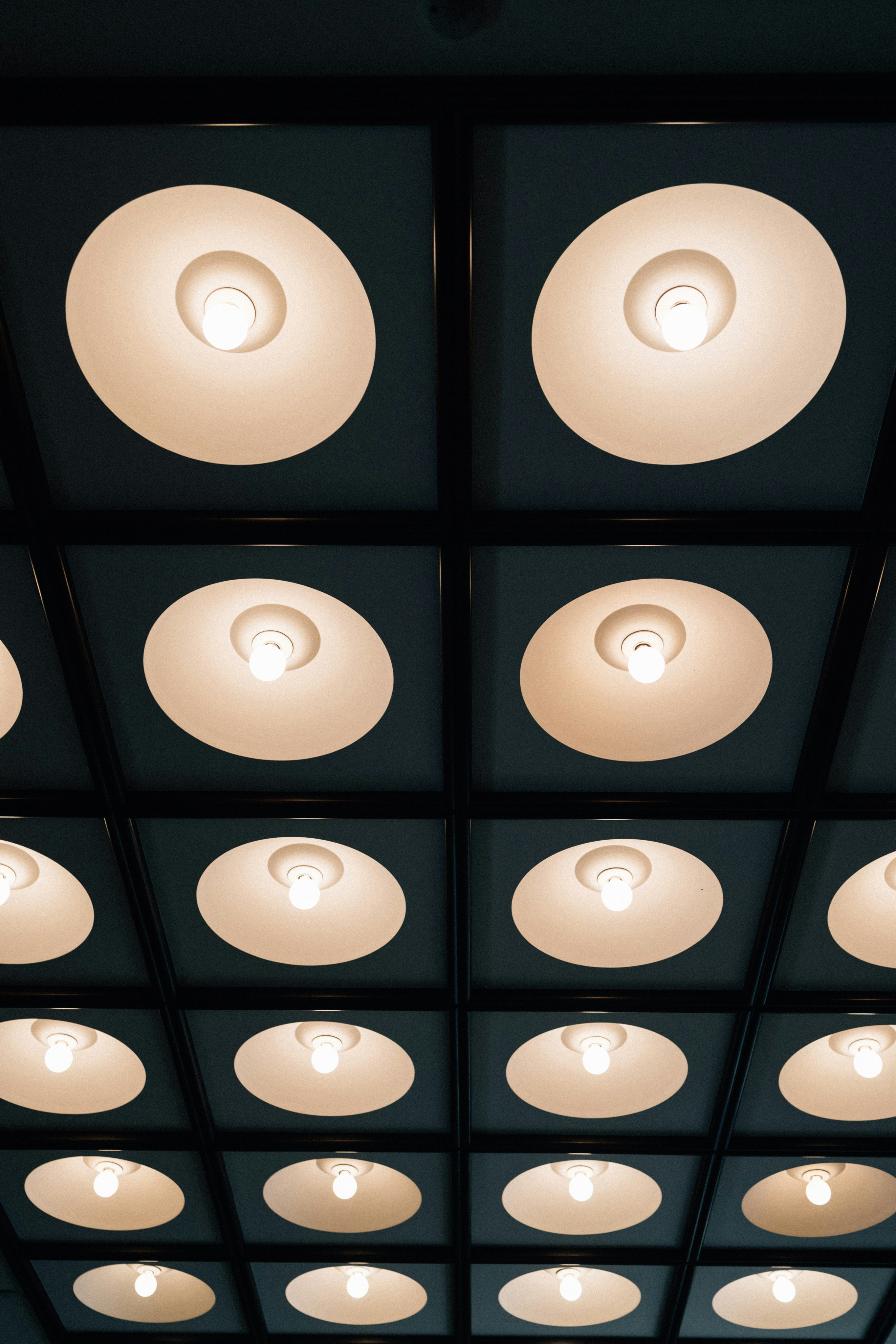 Recessed ceiling lights illuminate a dark room.