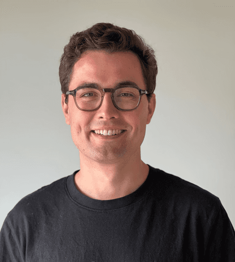 A man in a suit and tie leaning against a wall