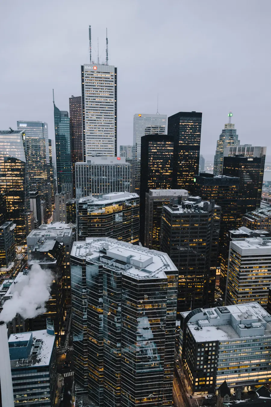 Aerial view of downtown Toronto, Canada, with snow-covered rooftops and lit office towers.