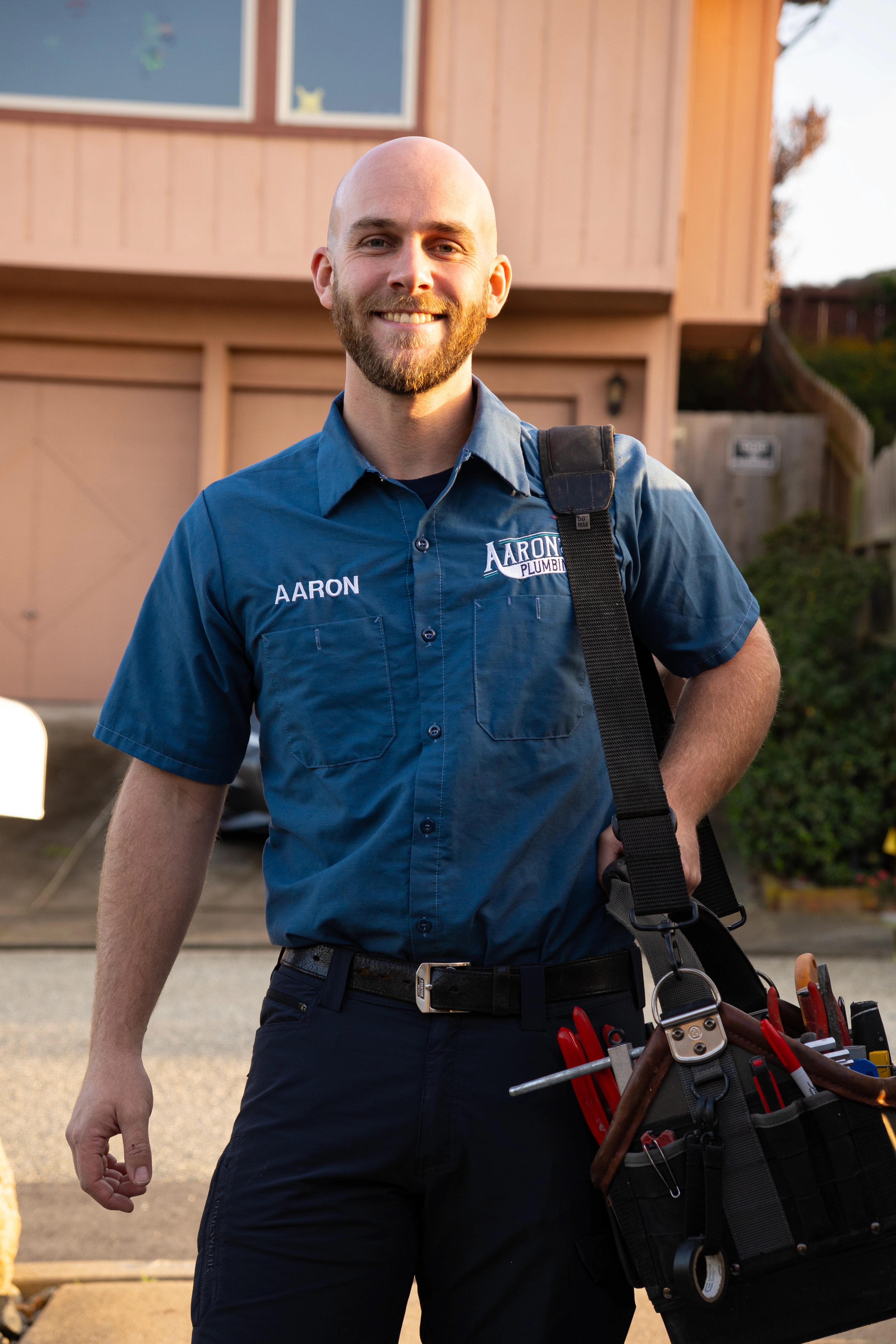 Aaron Lindvall, owner of Aaron's Plumbing, standing confidently in uniform with his fully-stocked tool bag, ready to serve residential clients across Salinas and the Central Coast.