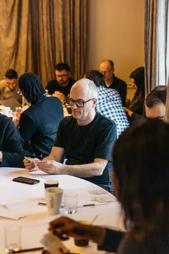 People sitting around a table with papers and cups.