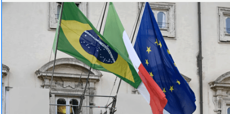 Aerial view of a winding road surrounded by dense green and yellow trees, showcasing nature’s vibrant colors.