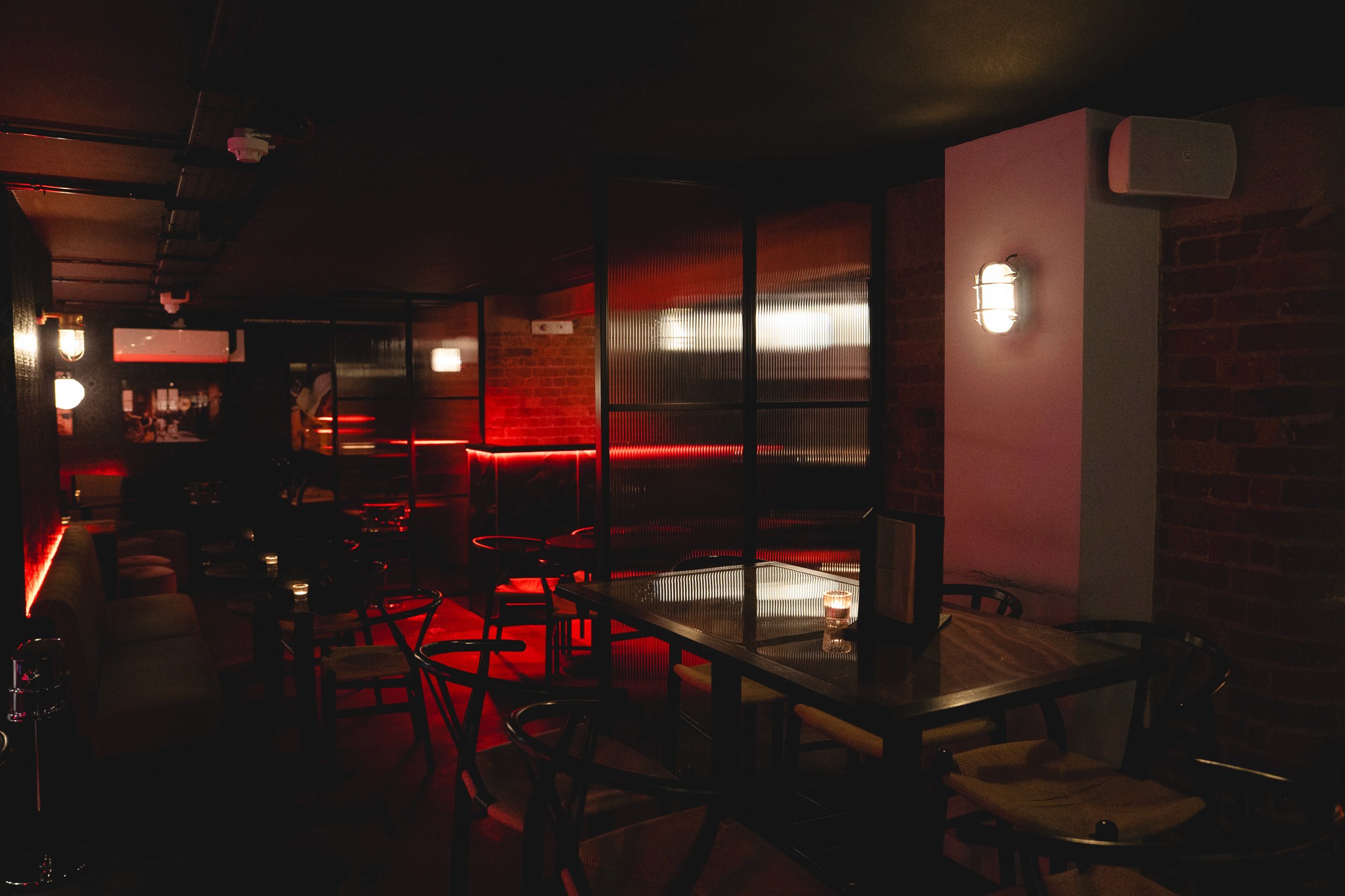 White plate with roasted chicken served in a golden sauce with herbs and capers, placed on a terrazzo tabletop in sunlight.