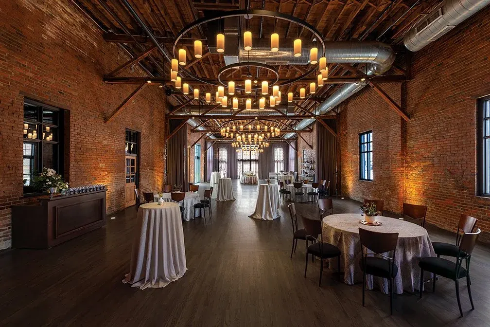 Brick Grande Hall with candle chandeliers and cocktail tables