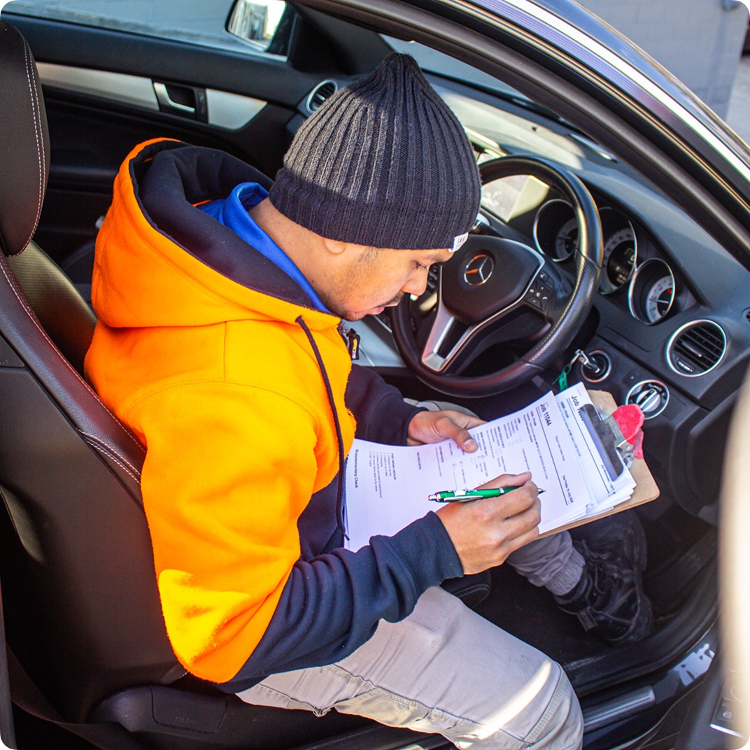 Man in car filling out paperwork