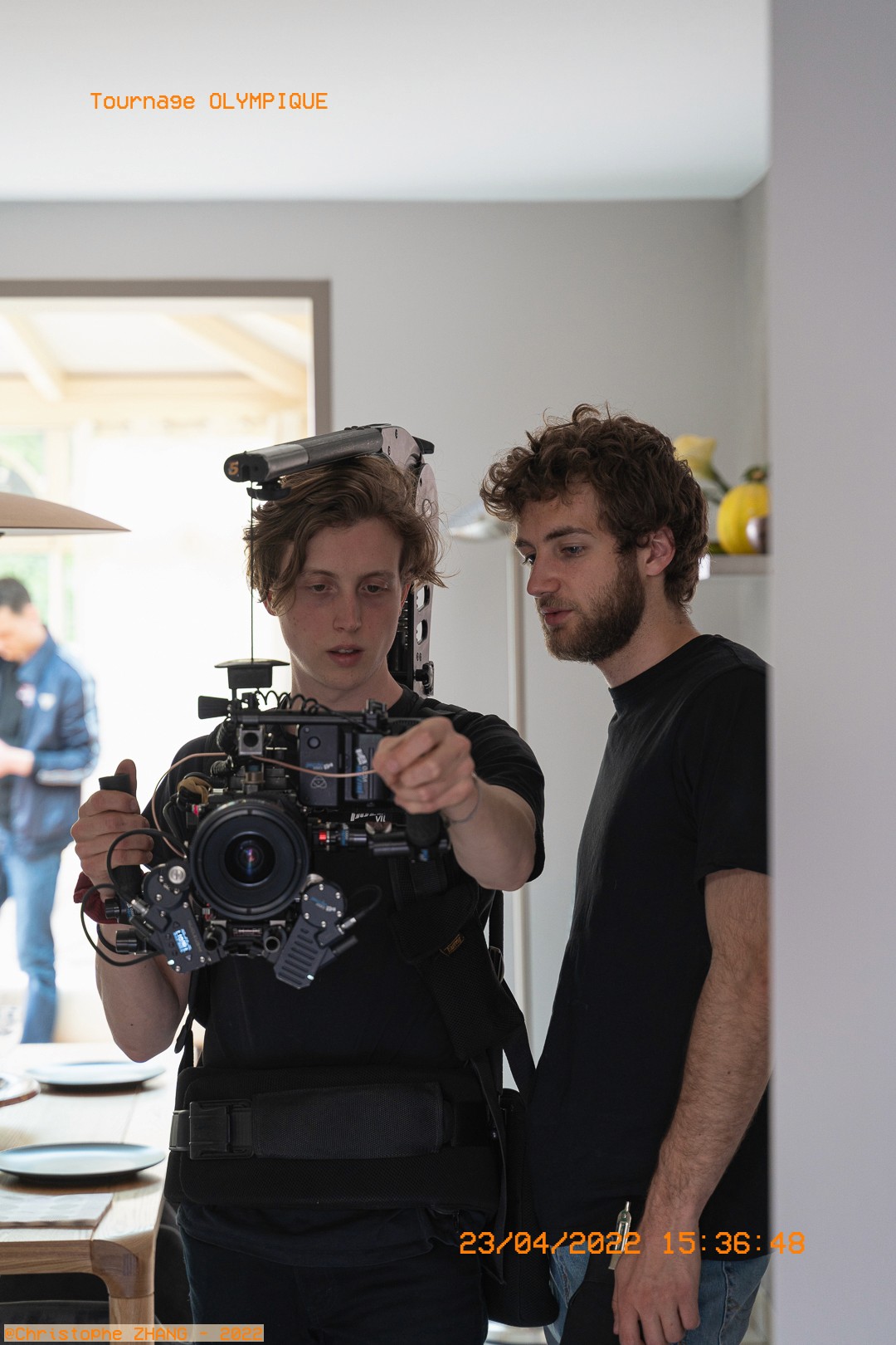 Réglages précis sur une caméra cinéma entre deux membres de l'équipe.