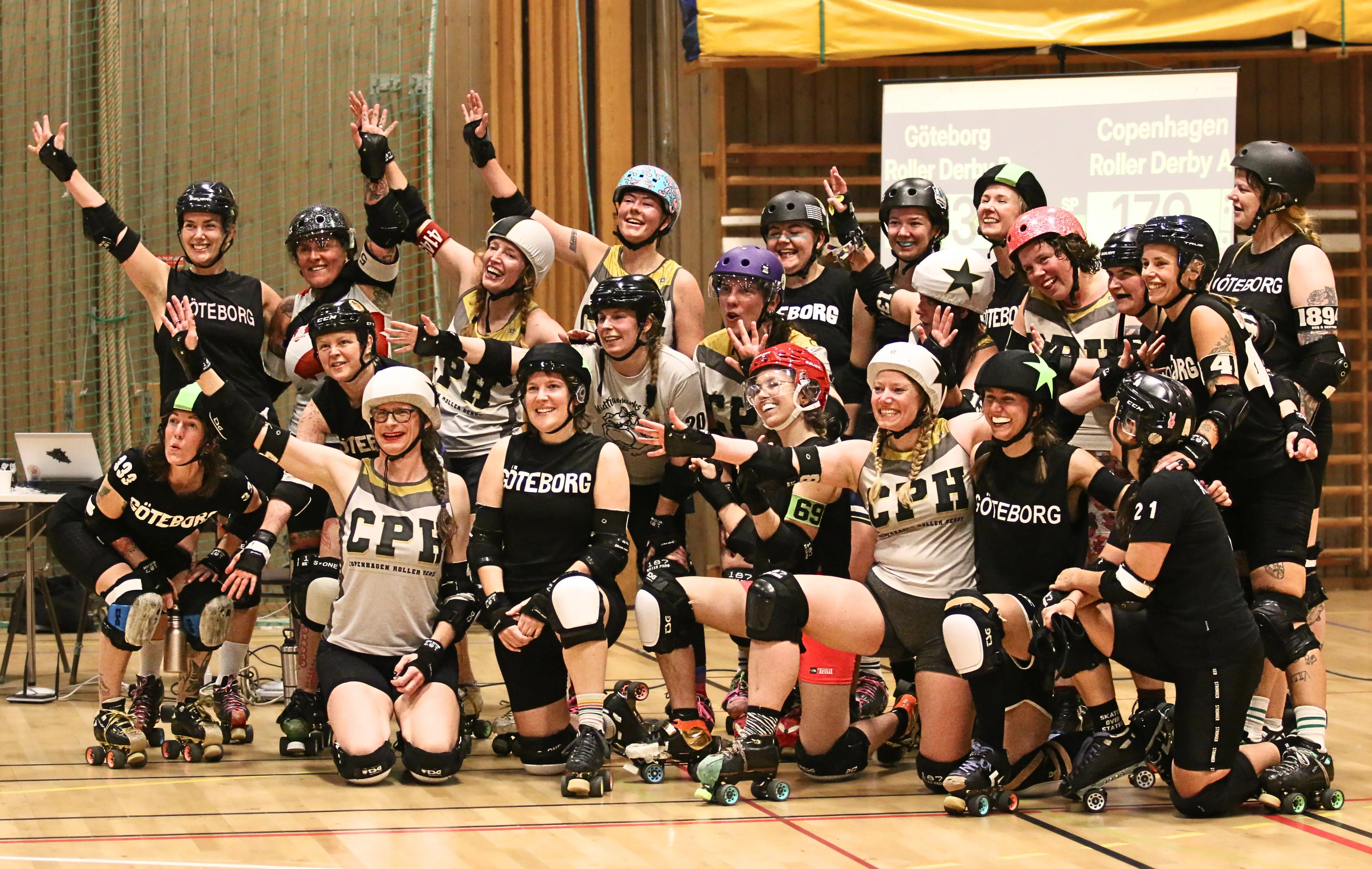 Two roller derby teams posing for a group photo.